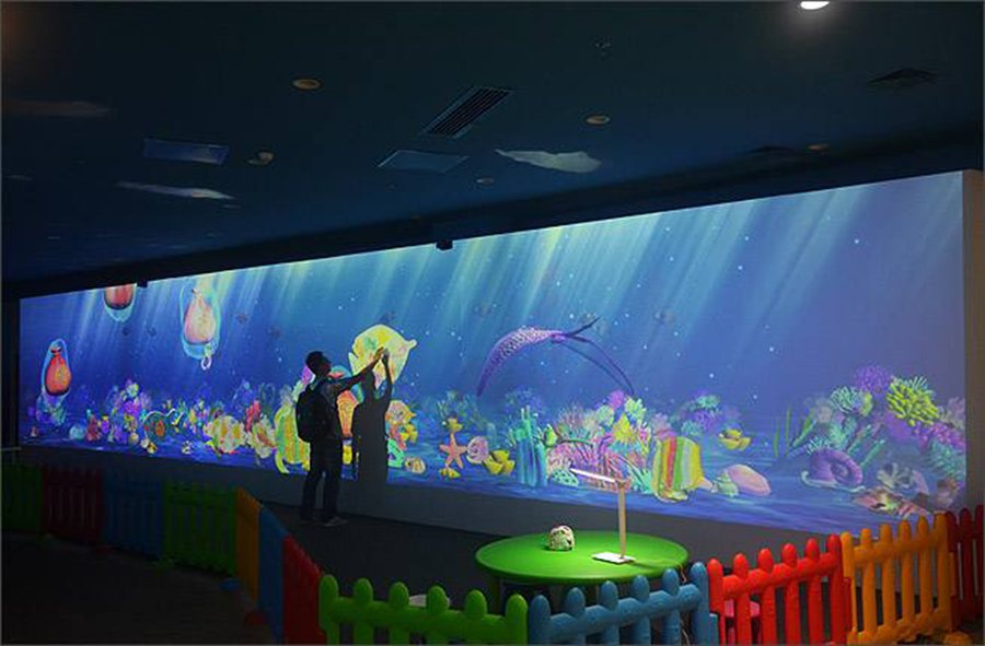 大型壁面の海中映像に来場者が手で触れるインタラクティブウォール